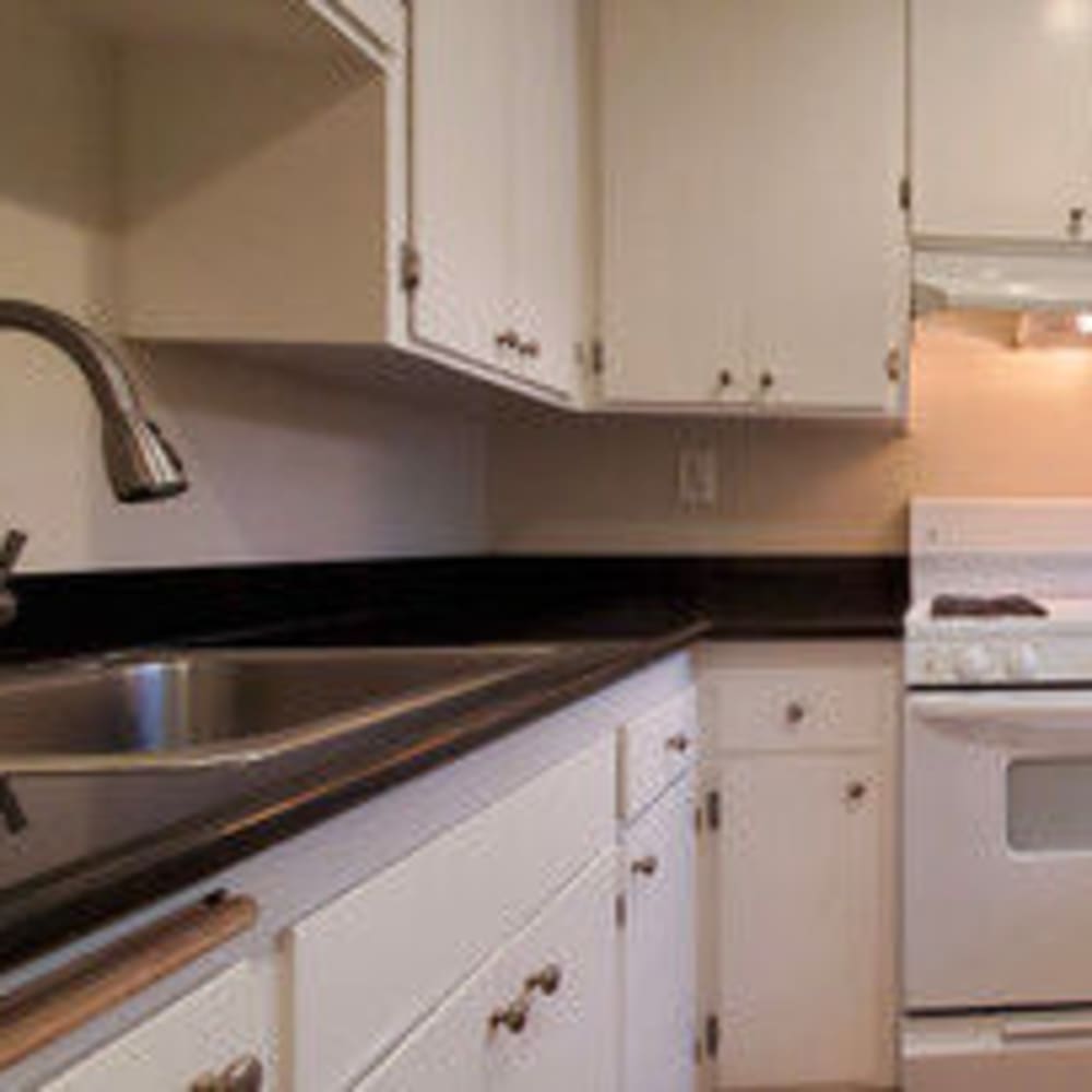 Kitchen equipped with gooseneck-sink with all white appliances at Mission Rock at North Bay in Novato, California