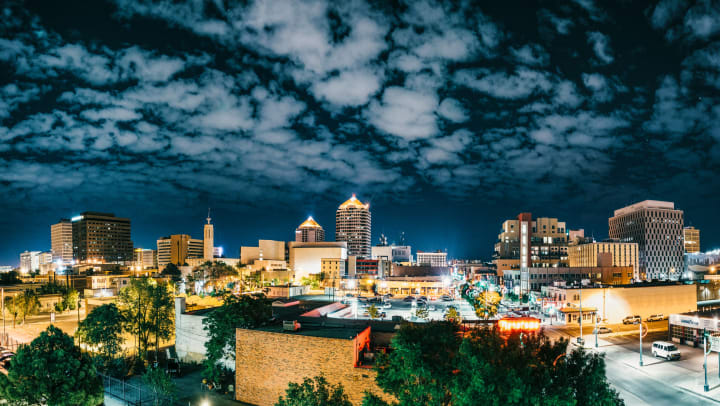 An evening cityscape view of Albuquerque NM with cloudy skies | facts about Albuquerque