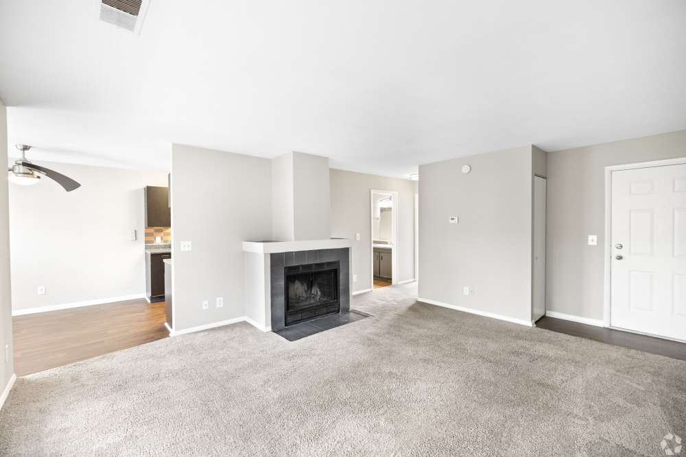 living room with wall to wall carpeting and fireplace *in select homes