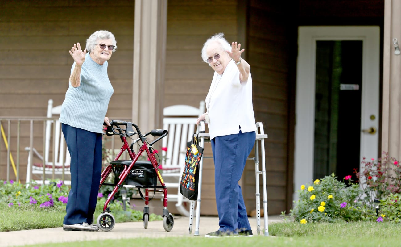 Two resident friends waving hello on their walk at Providence Assisted Living in Cleveland, Mississippi.