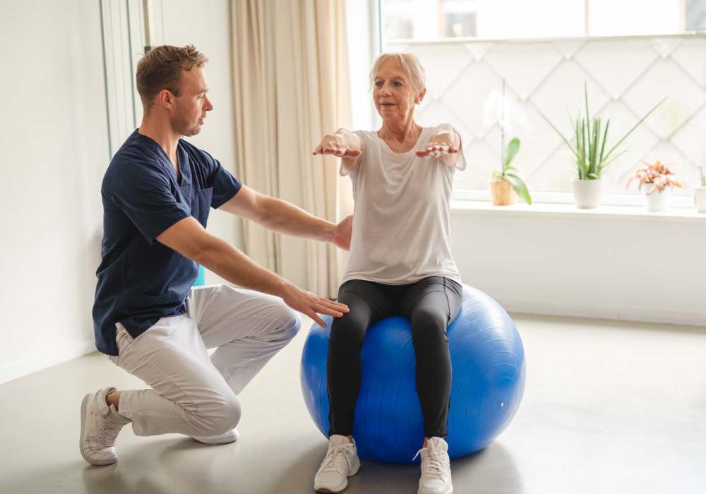 Resident on a medicine ball at Clearwater Living in Newport Beach, California