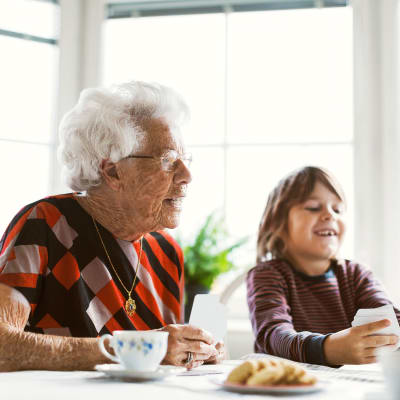 Resident and her grandson playing cards with community friends at Cascade Park Vista Assisted Living in Tacoma, Washington