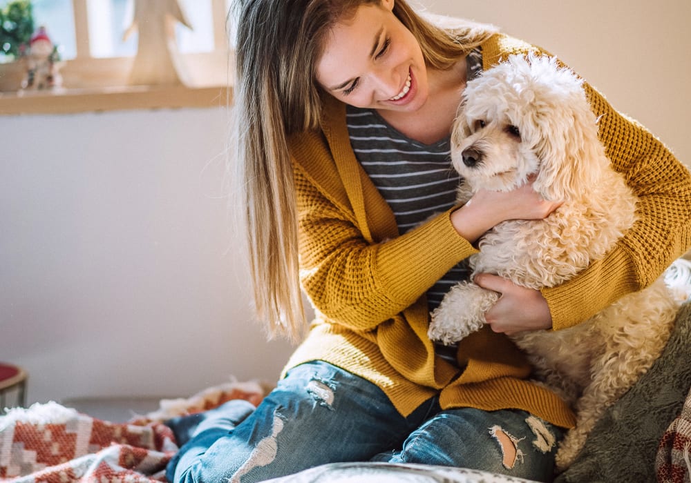Resident hugging their dog at Solana Stapleton Apartments in Denver, Colorado