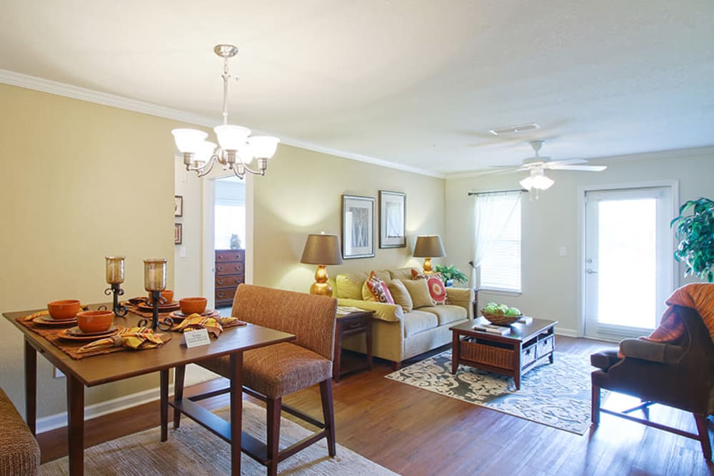 Dining table and living room in an open concept model apartment home at Parc at Flowing Wells Apartment Homes in Augusta, Georgia