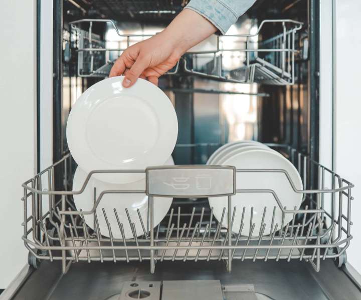 Resident taking plate from dishwasher at Maplewood Court in Bridgeport, Connecticut