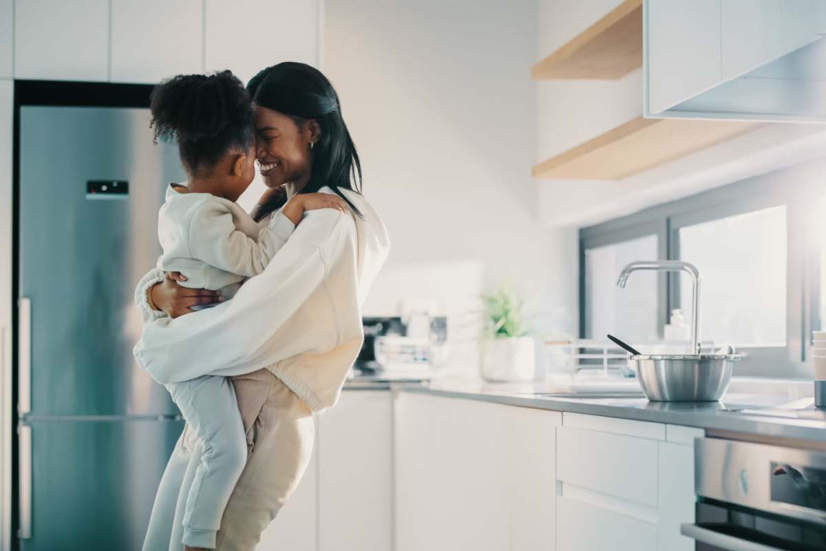 Happy woman with her child in apartment kitchen at Falls Creek in Sanford, North Carolina