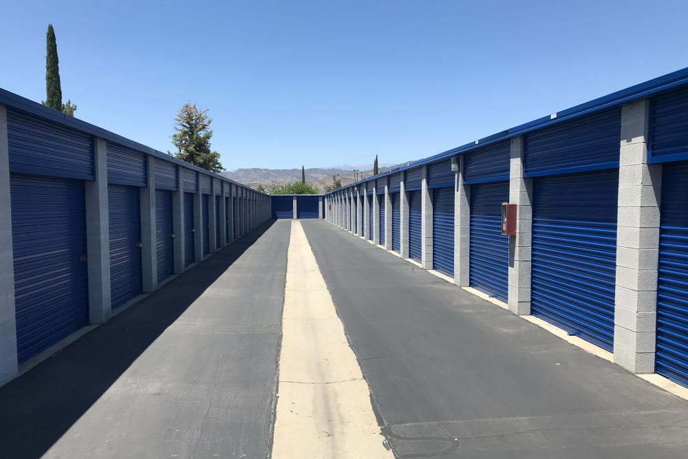 Drive-up access storage units with blue doors at A-American Self Storage in Hemet, California