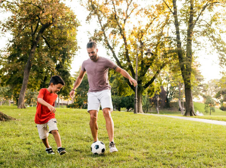 Father playing soccer with his kid at park near Manchester Court in Modesto, California