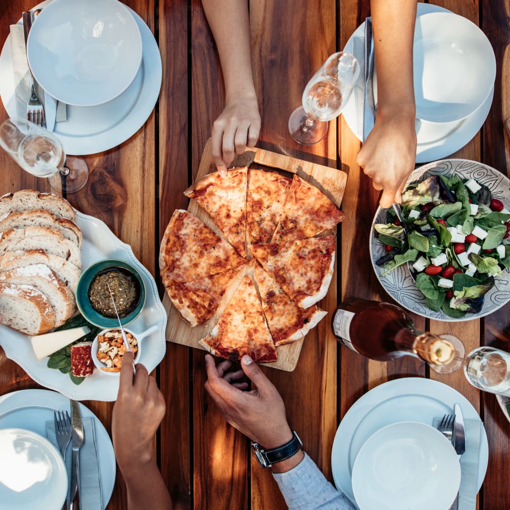 Residents sharing pizza and salad near Bellrock Memorial in Houston, Texas