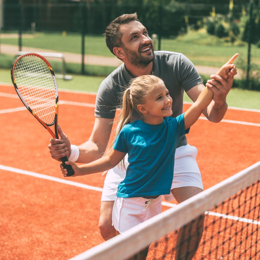 Father and daughter playing tennis at Flats at East Atlanta in Decatur, Georgia