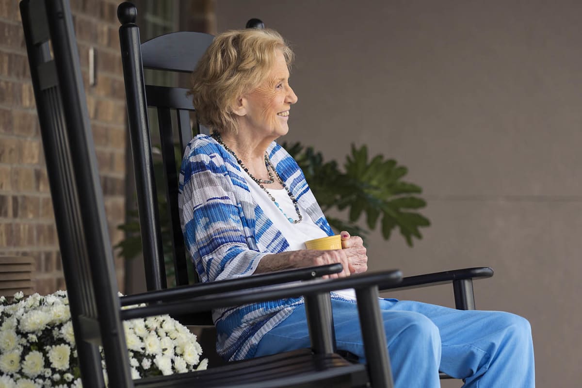 A resident enjoying her coffee outside at Oxford Glen Memory Care at Grand Prairie in Grand Prairie, Texas