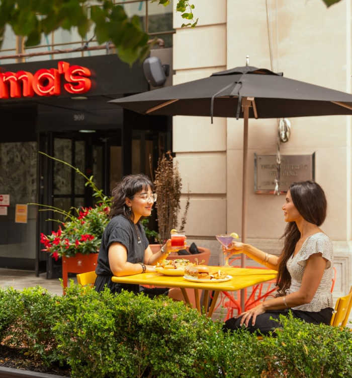 Two women eating outside Wilma's near The Residences at Christina Landing in Wilmington, Delaware