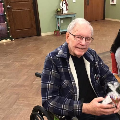 Resident with a festive plant arrangement at Oxford Glen Memory Care at Grand Prairie in Grand Prairie, Texas