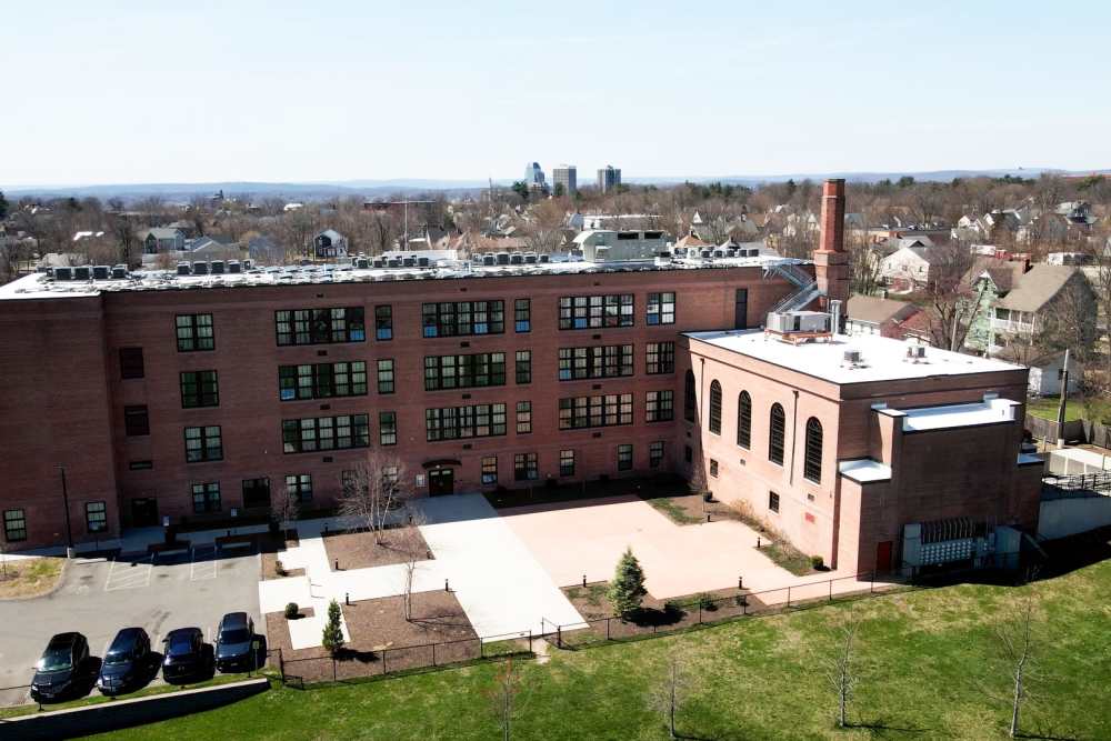 Aerial shot of the back exterior of building with lots of windows at Elias Brookings Apartments in Springfield, Massachusetts