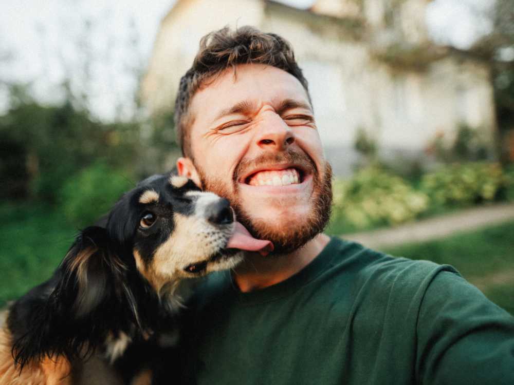 A resident with his pet dog near 83 West Townhomes in West Bloomfield Township, Michigan 