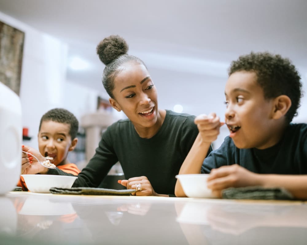 A resident eating cereal with her children at Orleck Heights in San Diego, California