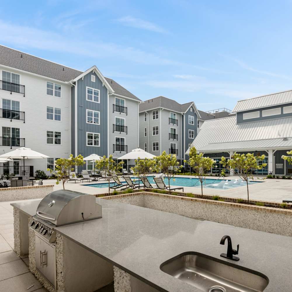 Grills by the swimming pool of a Drucker + Falk multifamily property