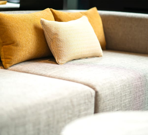 A bright apartment living room with decorative pillows on a couch at The Courts of Avalon in Pikesville, Maryland The Courts of Avalon in Pikesville, Maryland