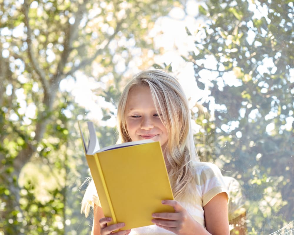 Resident child reading a book in her new home at Sofi Berryessa in San Jose, California