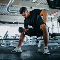 A man lifting weights in the fitness center at Reagan Crossing in Covington, Louisiana