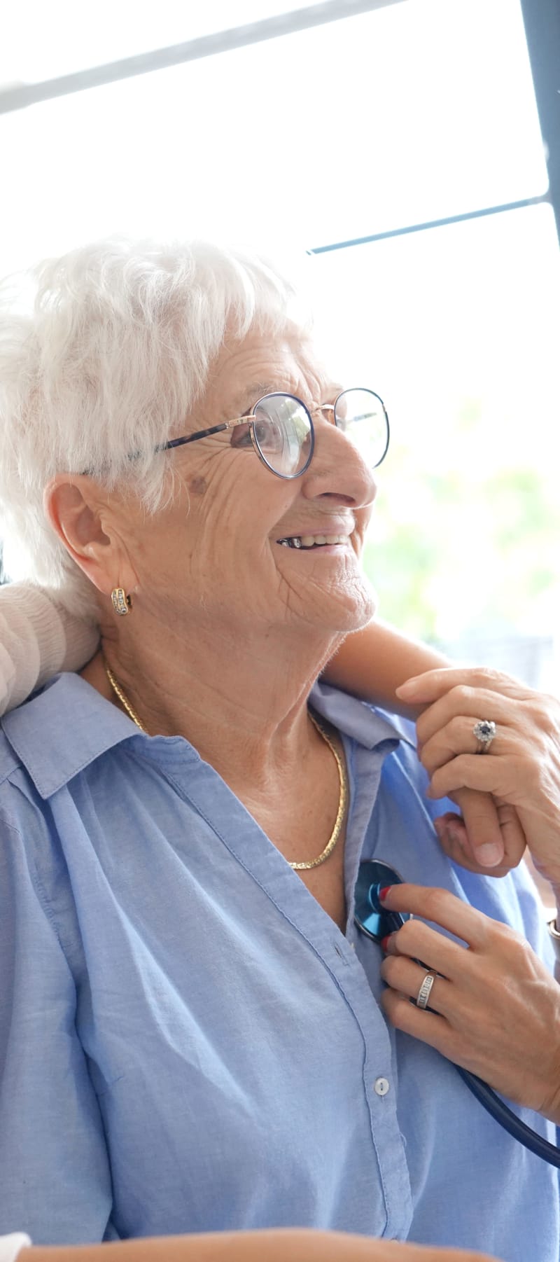 Resident having her heartbeat read by a caretaker at East Troy Manor in East Troy, Wisconsin