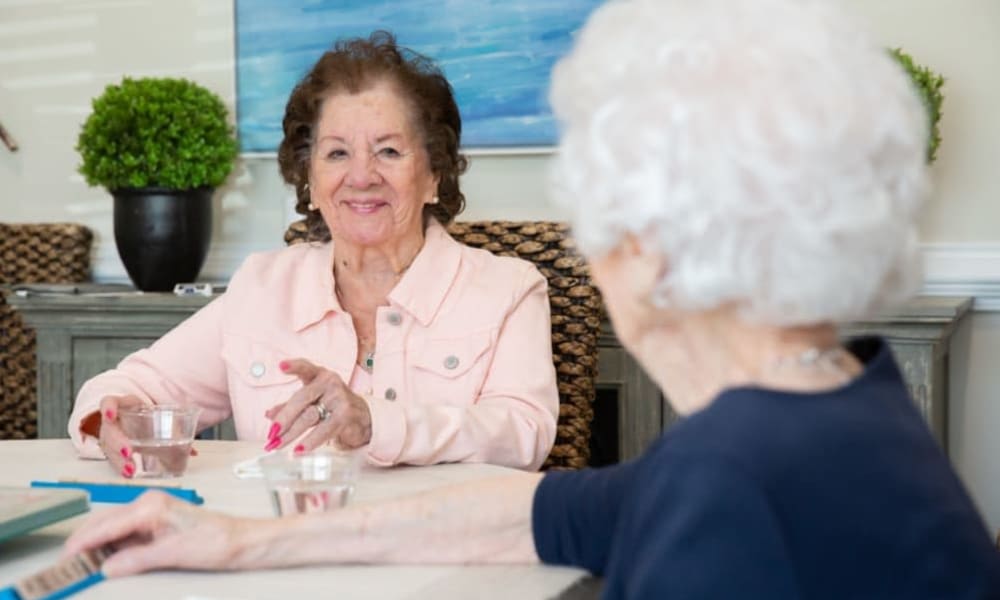 Two residents drinking water and talking at The Mansions at Gwinnett Park Assisted Living and Memory Care in Lawrenceville, Georgia