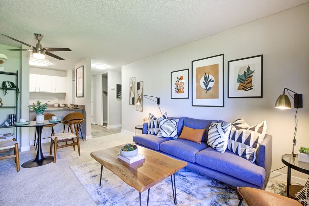 Large bed in carpeted bedroom with sitting chairs at Terra Apartment Homes in Federal Way, Washington