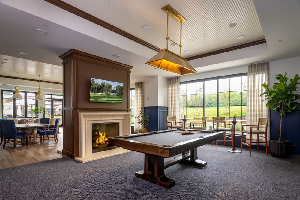 Clubhouse with fireplace and pool table at Amira Minnetonka in Minnetonka, Minnesota