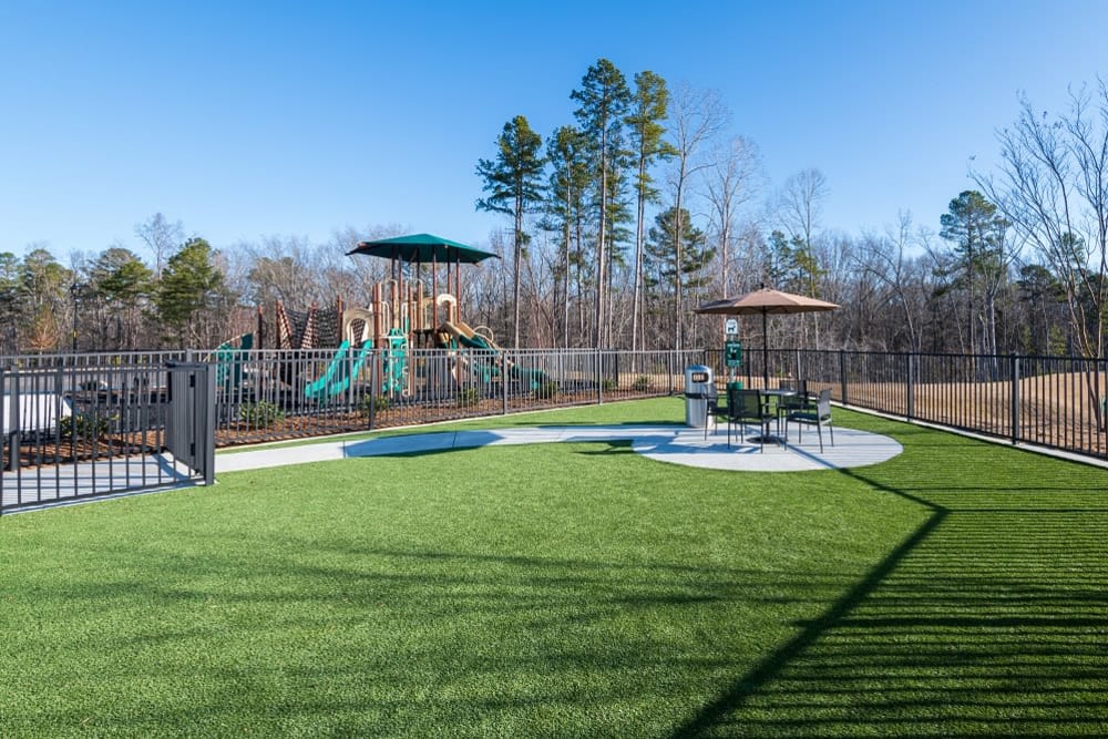 Fenced onsite dog park with seating and a clean-up station at The Reserve at Patterson Place in Durham, North Carolina