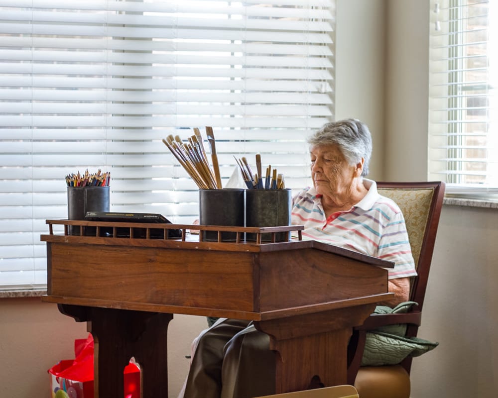 Woman resident enjoying painting at Iris Memory Care of NW Oklahoma City in Oklahoma City, Oklahoma. 