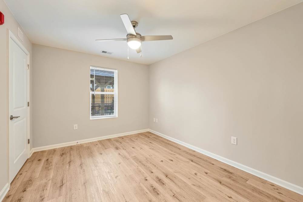 Spacious room with wood-style flooring, ceiling fan, and window for natural light at Hawkins Pointe in Hendersonville, North Carolina