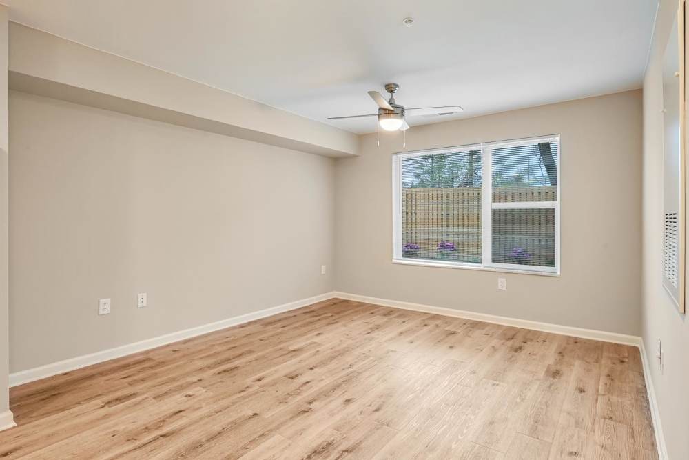 Spacious living area with wood-style flooring and large windows for natural light at Hawkins Pointe in Hendersonville, North Carolina