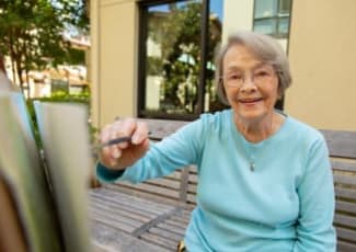 A resident painting outside at Courtyards at Berne Village in New Bern, North Carolina