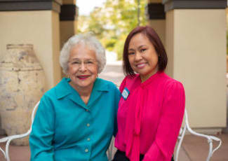 A happy resident with her caretaker at Sunset Lake Village Senior Living in Venice, FL
