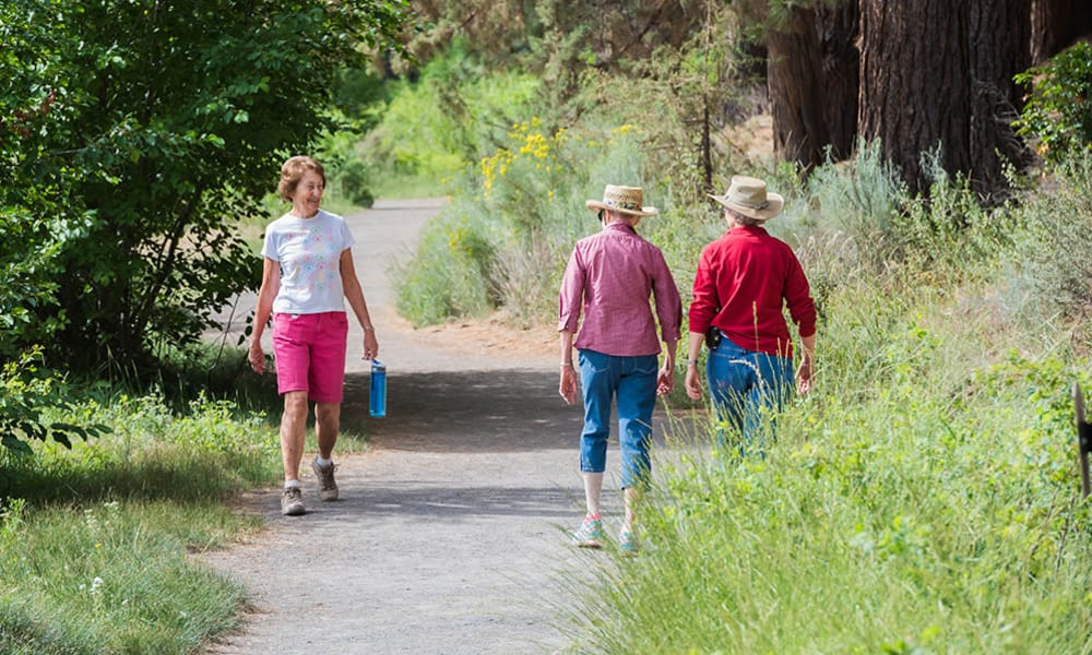 Residents hiking along a paved trail at Touchmark at Mount Bachelor Village in Bend, Oregon