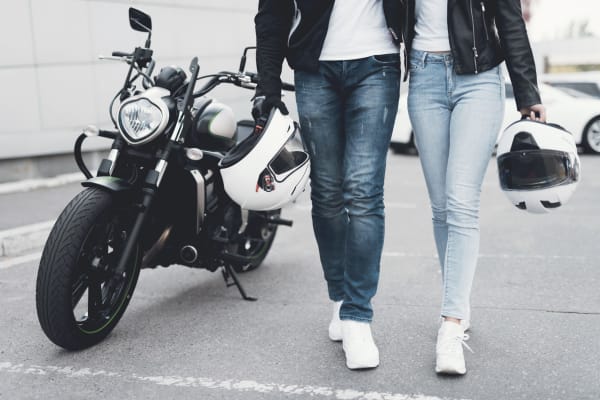 Man and woman walking away from motorcycle