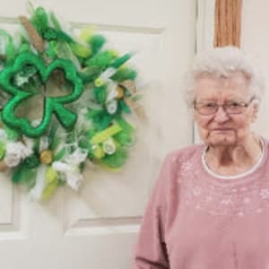 Resident Leona standing by the new wreathe she made for her Dare to Dream event at Addington Place of Carroll in Carroll, Iowa