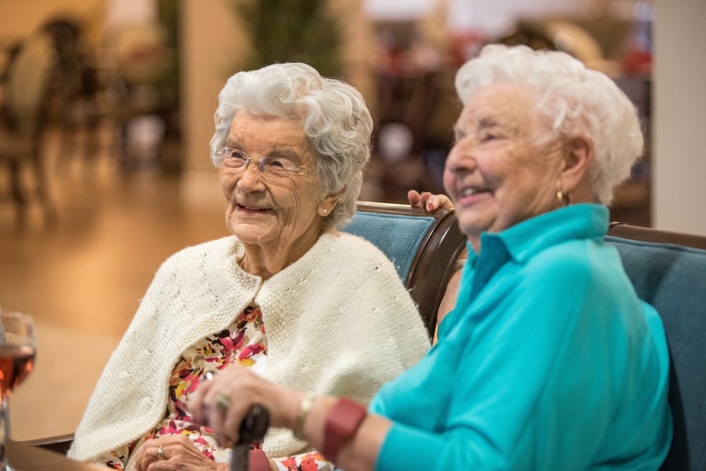 Two residents sitting on a couch at Inspired Living Lewisville in Lewisville, Texas. 