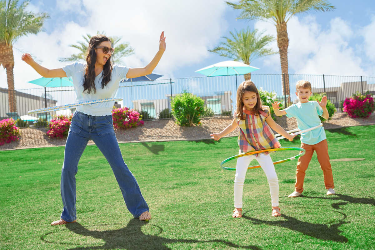 A family playing in the grass at BB Living Desert Ridge in Phoenix, Arizona