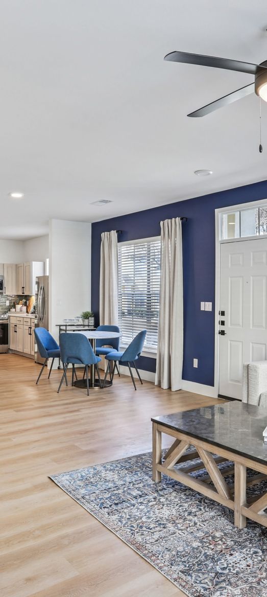 A kitchen with a bar and stools, providing a cozy and functional space for dining and socializing at Flatiron District at Austin Ranch, The Colony, Texas