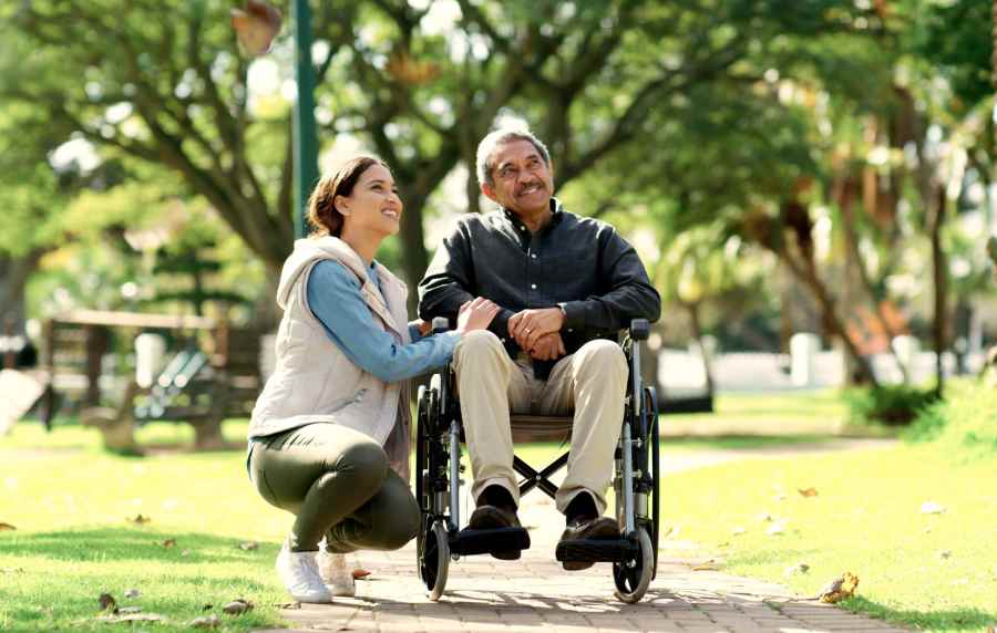 Resident in a wheelchair at a park with another resident near UCE Apartment Homes in Fullerton, California