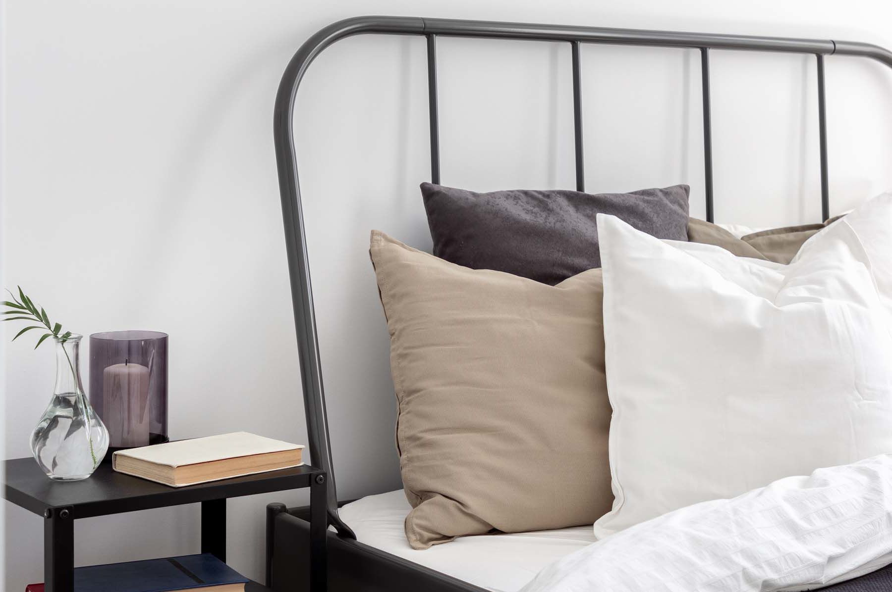 Modern bed frame and bedside table in a bedroom at Castlebar Apartments in Bozeman, Montana