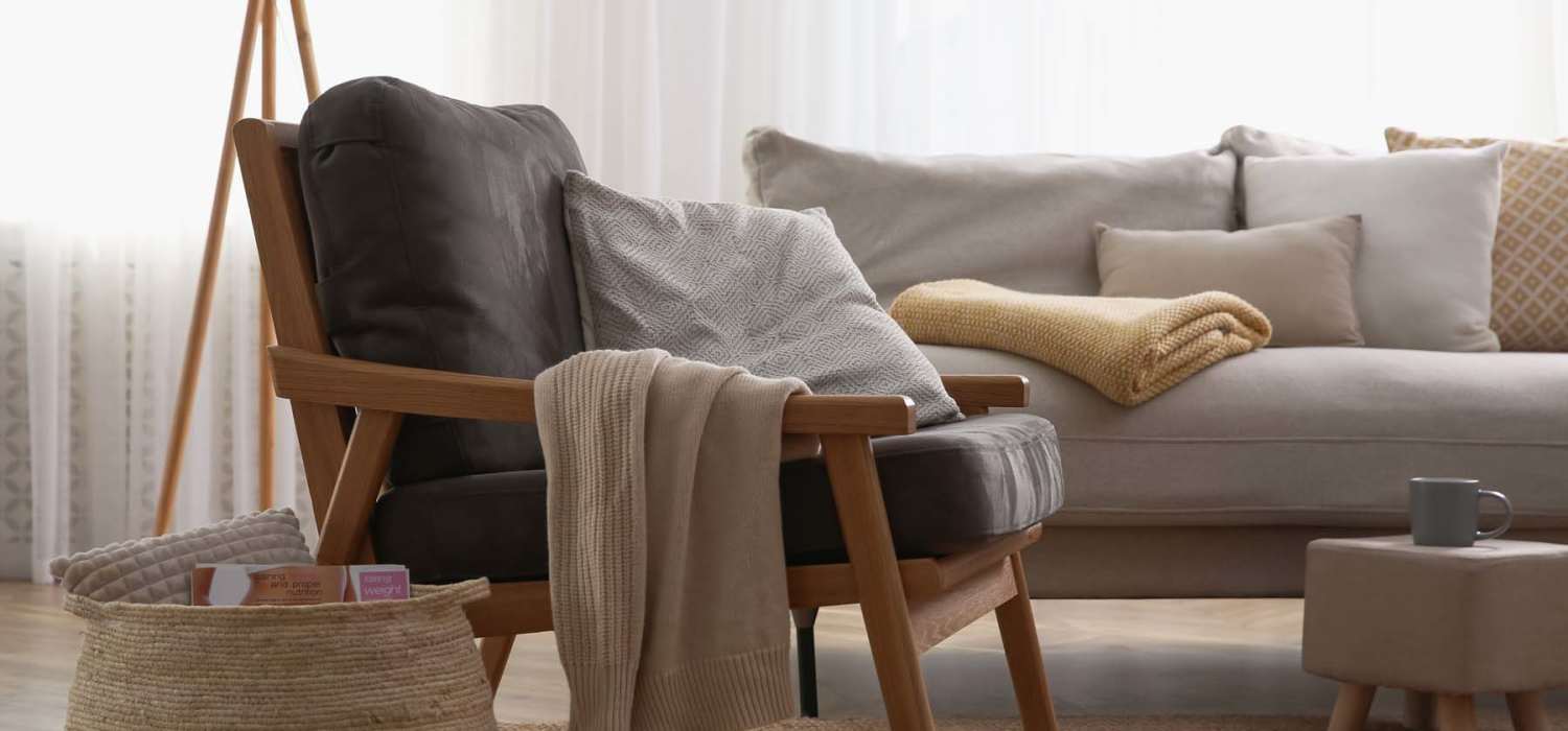 Chair and sofa in a cozy living room at Spring Hollow Apartments in Brighton, Colorado