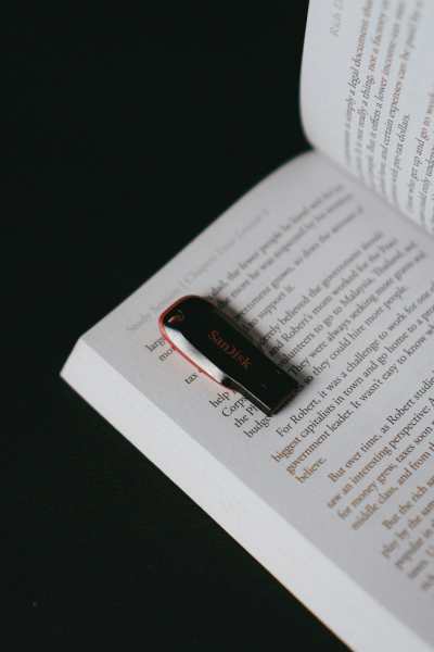 A USB flashdrive sits on top of an open book