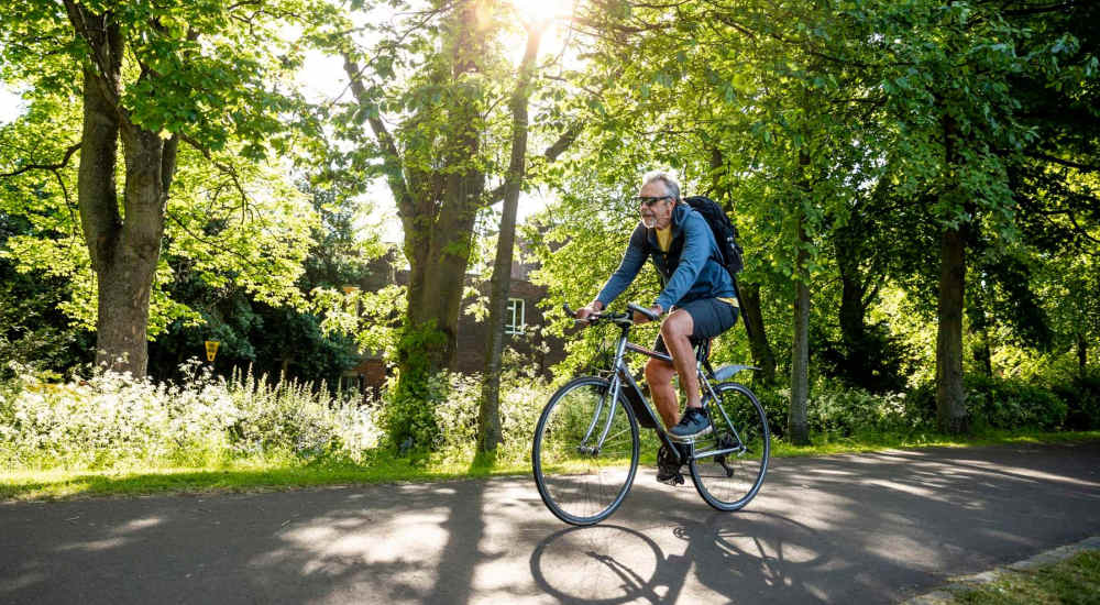 Resident man cycling at a park near The Hayes Apartments in Fort Worth, Texas