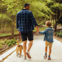 A man and his son walking their dog near Residences at Congressional Village in Rockville, Maryland