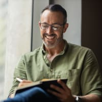 A man writing in a journal at The Highland in Augusta, Georgia