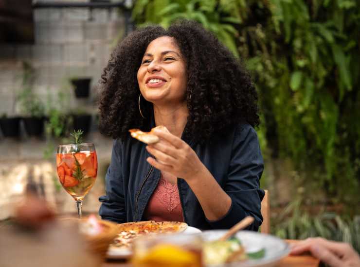 Woman enjoying pizza and drink at outdoor table Pinnacle at Afton in Richmond, Virginia 