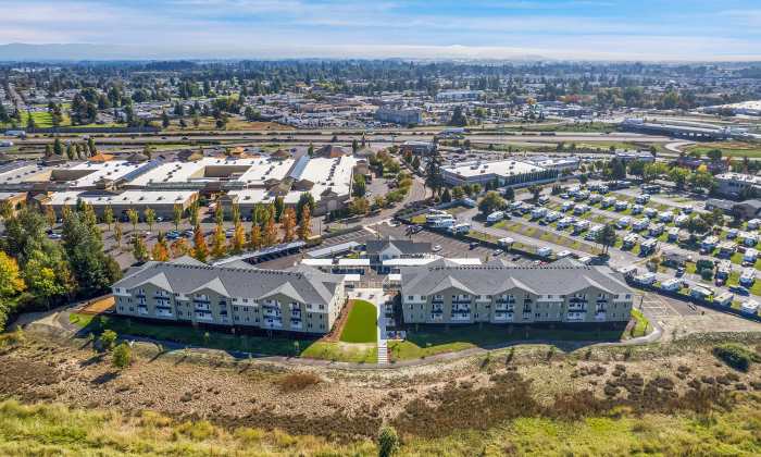 Aerial view of new apartment community surrounded by green space and parking areas at Tilian Point in Woodburn, Oregon