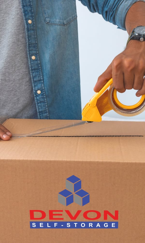 Man taping up a box to be stored at Devon Self Storage in Spring, Texas
